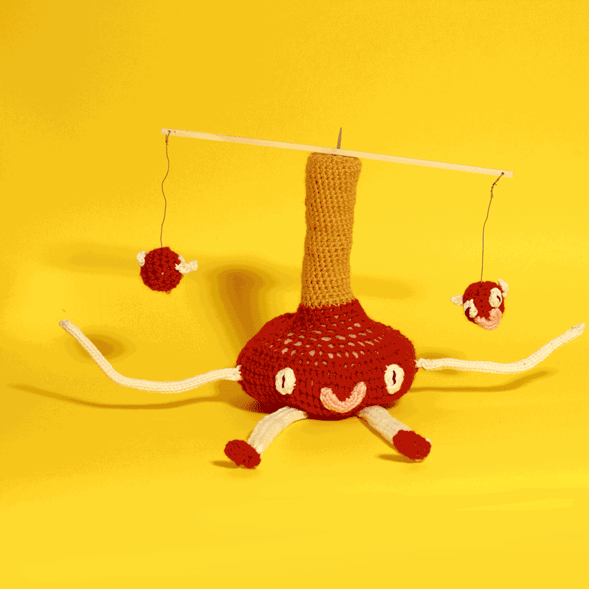 An animation of a knitted plush toy with a long head pushes two mini toys that are mounted to its head like a carousel on a yellow background